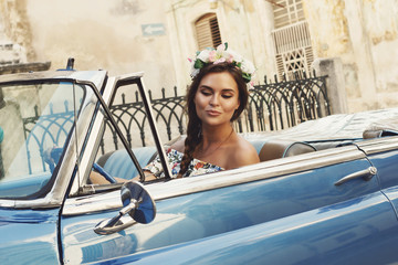 Beautiful woman driving a retro convertible car