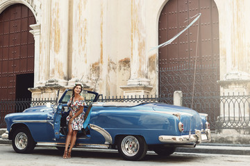 Woman wearing beautiful dress and retro convertible car