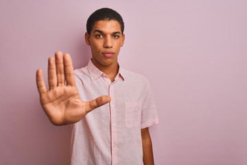 Young handsome arab man wearing casual shirt standing over isolated pink background doing stop sing...