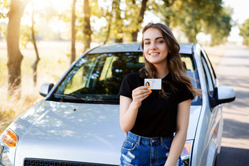 Teenader is happy to receive driving licence. Concept of buying first car - obrazy, fototapety, plakaty