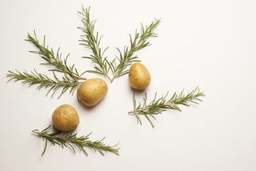 Rosemary with raw Potatoes on wooden background bamboo