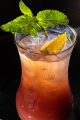 Colorful cocktail in glass on bar counter in pub or restaurant on bright blurred background closeup