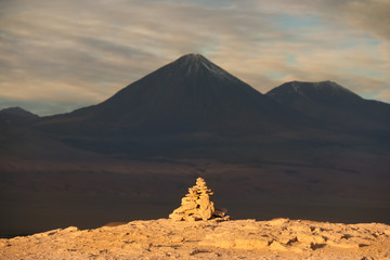 Stacking Stones in Atacama Desert with Licancabur Volcano on Background