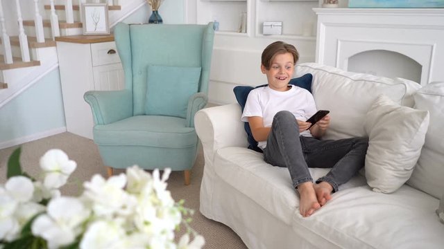 Kid using phone for gaming. boy celebrating victory in video game