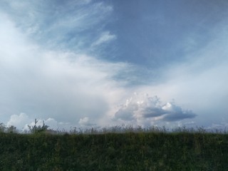 Obraz na płótnie Canvas storm clouds over green field