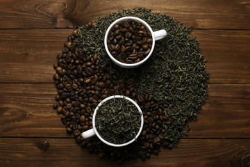 Yin-yang composition with coffee and tea on wooden table