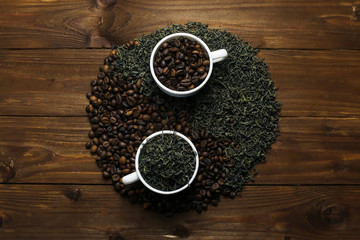 Yin-yang composition with coffee and tea on wooden table