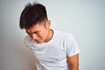 Young asian chinese man wearing t-shirt standing over isolated white background Suffering of backache, touching back with hand, muscular pain