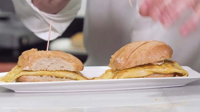 Chef preparing delicious typical Spanish food, Omelette tapa or Pintxo of omelette .