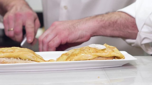 Chef preparing delicious typical Spanish food, Omelette tapa or Pintxo of omelette .