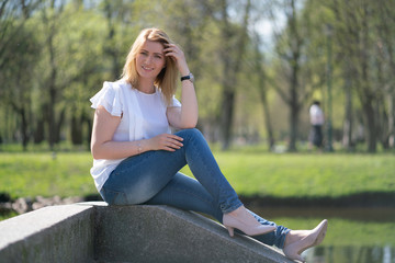 pretty woman relaxing by walking in the city park in jeans outfit