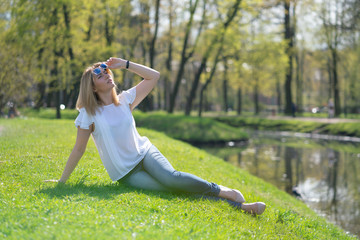 Fototapeta premium pretty woman relaxing by walking in the city park in jeans outfit