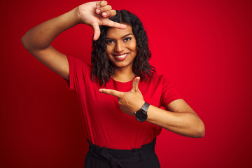 Beautiful transsexual transgender woman wearing t-shirt over isolated red background smiling making frame with hands and fingers with happy face. Creativity and photography concept.