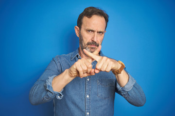 Handsome middle age senior man with grey hair over isolated blue background Rejection expression...