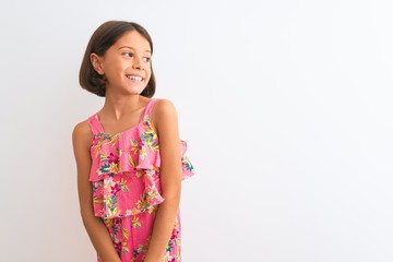 Young beautiful child girl wearing pink floral dress standing over isolated white background...