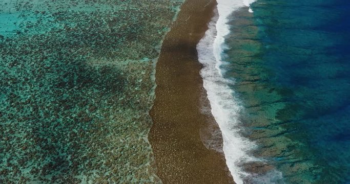 Aerial view of island reef with breaking waves