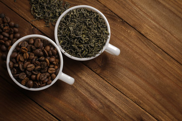 Cup with tea and coffee grains on wooden table