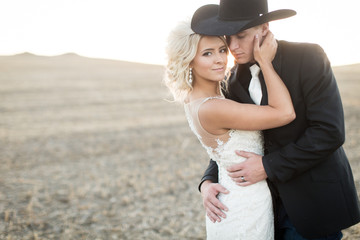 Romantic wedding portrait of an elegant country bride and cowboy groom 