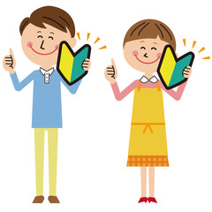 ポップなカップルの男女　初心者マークを持つ