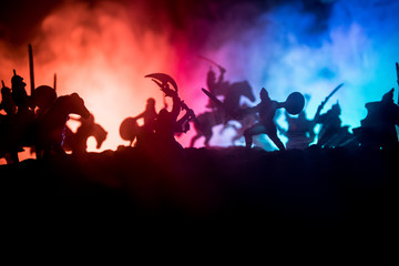 Fototapeta na wymiar Medieval battle scene with cavalry and infantry. Silhouettes of figures as separate objects, fight between warriors on dark toned foggy background with medieval castle.