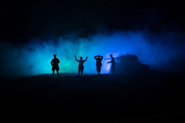 Battle scene. Military silhouettes fighting scene on war fog sky background. A German soldiers raised arms to surrender. Plastic toy soldiers with guns taking prisoner the enemy soldier.