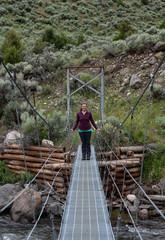 Woman Smiles While Standing on Footbridge