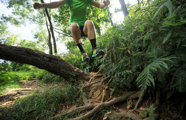 Ultramarathon runner cross country trail running in summer tropical rainforest