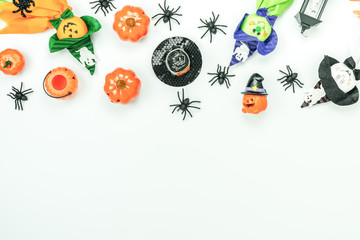 Table top view aerial image of decoration Happy Halloween day background concept.Flat lay accessories essential object to party the pumpkin & doll and candy on white wooden.Space for creative design.