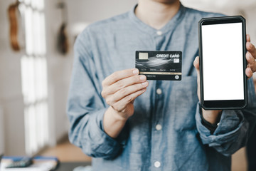 beautiful Woman showing credit card and smartphone before shopping website online, shopping concept