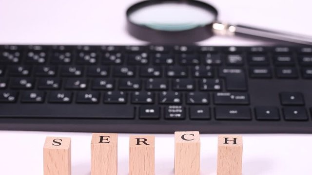 パソコンのキーボードと拡大鏡