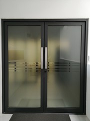 door is tinted with a black frame in the office building.