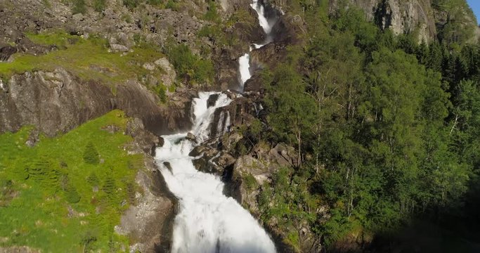 Aerial: Drone ascending over waterfall flowing from rocky cliff - Borgund, Norway