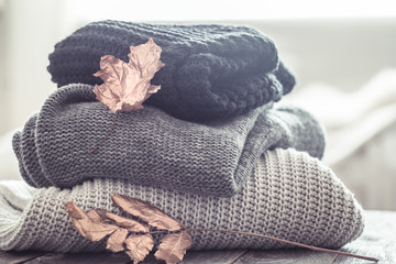 stack of cozy knitted sweaters in different colors.