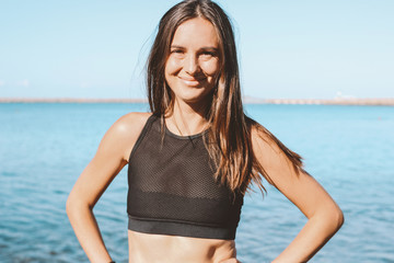 Young slim athletic long hair smiling woman in sportswear on the sea beach, healthy lifestyle