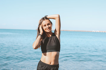 Young slim athletic long hair smiling woman in sportswear on sea beach, healthy lifestyle
