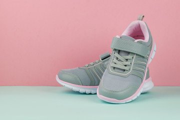 Gray sneakers for sports on a two-tone background.