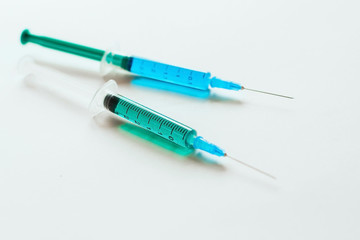 Fototapeta premium syringes with multicolored liquid on a white background.