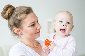 Childhood, family and motherhood concept - Mother holding sweet baby girl close-up