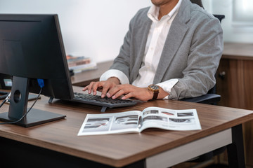 Closeup Asian Businessman in formal suit hand typing computer keyboard in office, business and technology workplace concept
