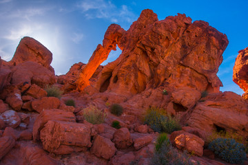 Sun lit rock formation in red sandstone cliffs glows in the desert
