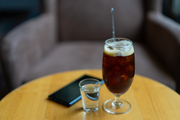 Black coffee and sweet water and mobile on the table relax by coffee concept
