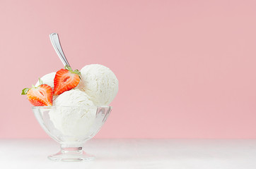 Seasonal sweet dairy dessert - creamy ice cream scoops in elegant bowl with silver spoon, strawberry slice in modern stylish pastel pink interior.