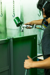 Spray booth painter cover steel in deep green paint.