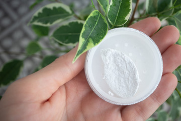 Round box of mineral powder in female palm in natural environment