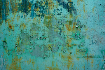 The texture of the old metal surface painted in blue-green color with large stains of rust