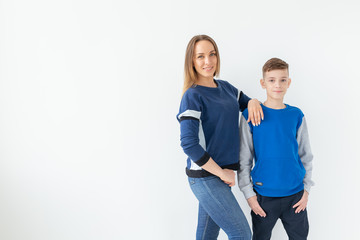 Parenting, family and single parent concept - A happy mother and teen son laughing and embracing on white background with copy space