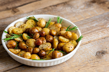 Young baked potatoes with rosemary. Fried dish for dinner. Bake in the oven and fry in a pan. Baked vegetables with butter and herbs