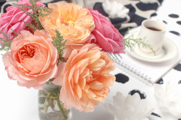 Bouquet of pink roses in vintage style on the home office table. Spring floral concept. Selective focus.