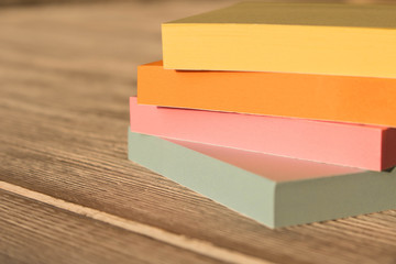 Packages of colorful stickers for notes on a wooden table.
