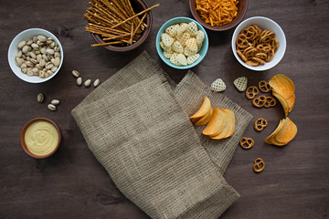 Oktoberfest with pretzels and various kinds of savory snacks. Beer snacks. Wood background. View from above. Place for text.